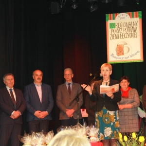 Grupa osób na scenie podczas pokazu regionalnych potraw powiatu łęczyckiego.