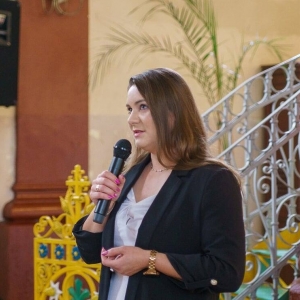 Pani Dyrektor Paulina Frontczak-Pawłowska przemawia do mikrofonu w kościele.