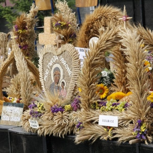 Wyeksponowany obrazek Św. Matki Boskiej pięknie przystrojony kwiatami i uplecionymi kłosami zbóż.