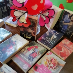 Kilka książek o miłości leży na stole ozdobionym kolorowymi serduszkami.