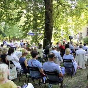 Goście festiwalu siedzący na krzesełkach na zielonym terenie wsłuchani w koncert „Chopin en Vacances”.