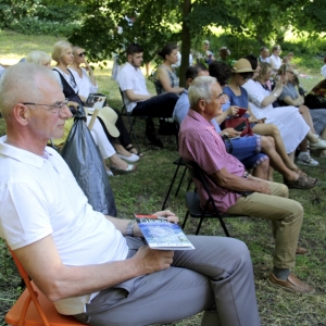 Wójt Gminy wraz z innymi gośćmi siedzącymi na krzesełkach na zielonym terenie słuchają koncertu „Chopin en Vacances” w Parskach.