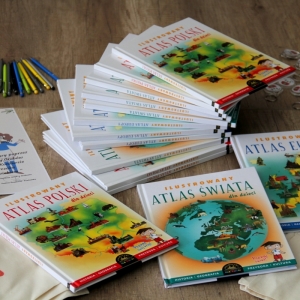 Atlasy Polskie i świata ilustrowane rozłożone na stole.