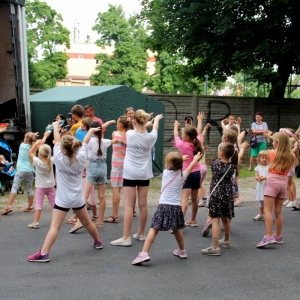 Kilkanaścioro dzieci i dorosłych podczas zabawy przed sceną.