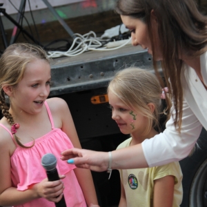Pani Dyrektor GCKB Grabów rozmawia z dwiema dziewczynkami używając mikrofonu.