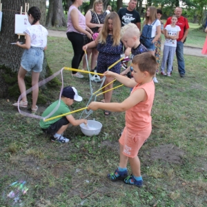 Grupka dzieci bawiąca się na trawniku.