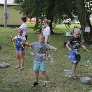 Grupka dzieci robiących ogromne bańki mydlane.