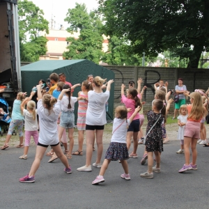 Kilkanaście dzieci i dorosłych bawiąca się na imprezie Bubble Disco w plenerze.