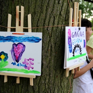 Wyeksponowane na drzewie dwie prace namalowanych przez dzieci kolorowych rysunków.
