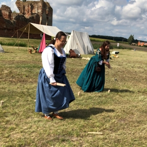 Dwie aktorki na spotkaniu rycerskim uczestniczące podczas zawodów na tle ruin starego zamku.