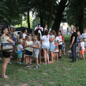Grupka dzieci podczas zabawy wraz z animatorką podczas pikniku.