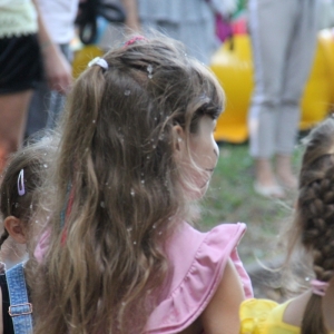 Dziewczynki patrzą w stronę bawiących się dzieci.