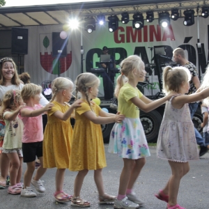 Grupka dzieci bawiąca się przed sceną. 