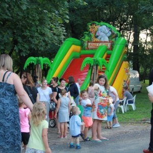 Grupka dzieci podczas zabawy na tle kolorowej dmuchanej zjeżdżalni.