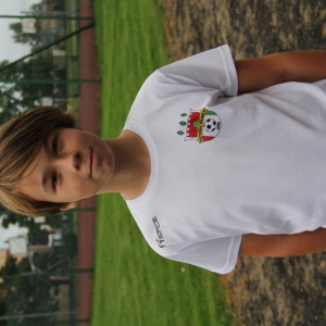 Chłopiec w białej koszulce z logiem Victoria Grabów.
