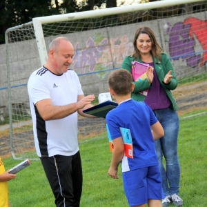 Trener i Pani Dyrektor Paulina Frontczak-Pawłowska klaszczą po wręczeniu chłopczykowi książki.