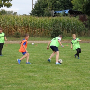 Dzieci w różnych znacznikach grają w piłkę nożną.