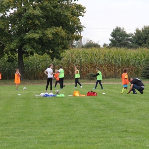 Dzieci przygotowują się do treningu na boisku.
