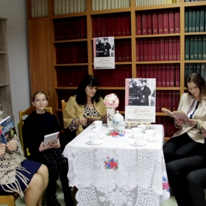 Pani Dyrektor Paulina Frontczak-Pawłowska wraz z innymi uczestnikami siedzą przy stoliku z plakatem „Moralności pani Dulskiej" i czytają książki.