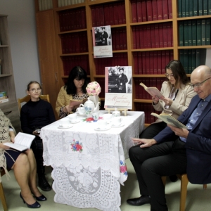 Pani Dyrektor Paulina Frontczak-Pawłowska wraz z innymi uczestnikami siedzą przy stoliku z plakatem „Moralności pani Dulskiej" i czytają książki.