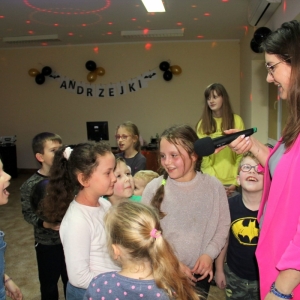 Uśmiechnięta grupka dzieci mówi do mikrofonu trzymającego przez Panią Dyrektor Paulinę Frontczak-Pawłowską.