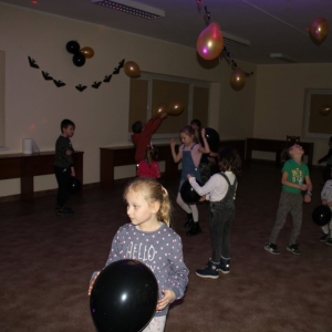 Dzieci tańczące i bawiące się balonikami na sali.