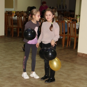 Dwie dziewczynki trzymające w rękach napompowane baloniki.