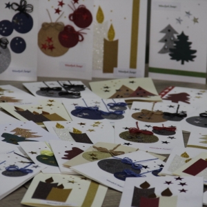 Własnoręcznie zrobione kartki świąteczne ustawione na stole.