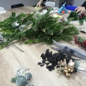 Stół z materiałami plastycznymi do robienia stroików świątecznych.