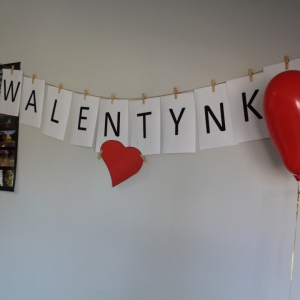 Ściana z napisem „WALENTYNKI" i balonami w kształcie serca.