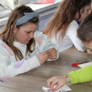 Dzieci robią bransoletki przyrządów plastycznych.