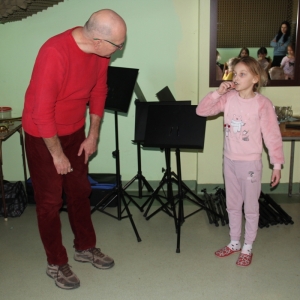 Nauczyciel uczy dziewczynkę grać na instrumencie.