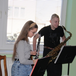 Chłopiec i dziewczynka przygotowują się do zagrania na swoich instrumentach.