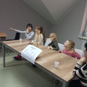 Grupa dzieci o nazwie „Drużyna Białych" siedzi przy stole i rozmawia.
