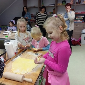 Dziewczynki przygotowują ciasto na faworki.