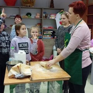 Dzieci wraz z prowadzącymi zajęcia przygotowują ciasto.