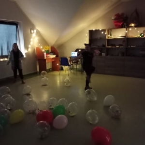 Dzieci bawią się wśród rozrzuconych balonów.