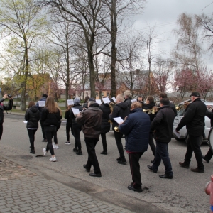Korowód Gminnej Orkiestry Dętej idzie po ulicy Grabowa. 