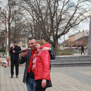Pan prowadzący trzymający mikrofon z uśmiechniętą mieszkanką Grabowa na tle pomnika Tadeusza Kościuszki.