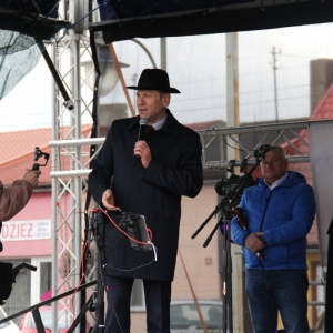 Jeden z mieszkańców gminy Grabów stoi na scenie z mikrofonem.