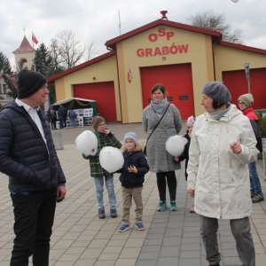 Grupka mieszkańców Grabowa z dwójką dzieci trzymające watą cukrową w rękach.