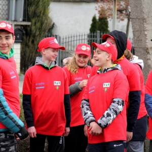 Kilka uśmiechniętych osób z drużyny czerwonej gry palanta. 