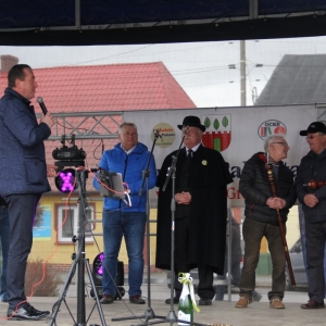 Senator RP P. Błaszczyk stoi na scenie z mikrofonem i przemawia do Króla Palanta i innych przedstawicieli wygranej drużyny.