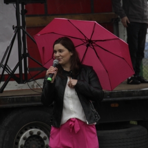 Uśmiechnięta Pani Dyrektor GCKB Grabów z różową parasolką.
