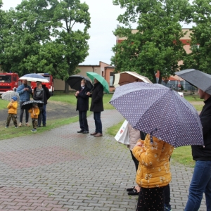 Grupka gości z parasolami uczestniczących w pikniku „Dzień Rodziny".
