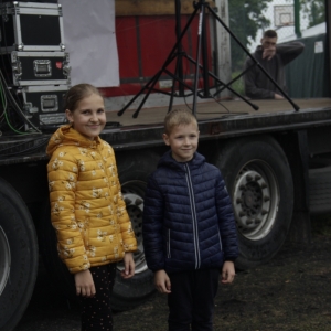 Uśmiechnięta dziewczynka i chłopiec przed sceną podczas pikniku „Dzień Rodziny" w Grabowie.