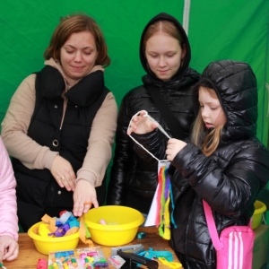 Cztery uśmiechnięte dziewczynki przy zielonym stoisku podczas zabawy na pikniku „Dzień Rodziny" w Grabowie.