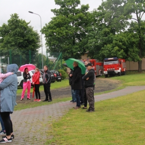 Grupka gości z parasolami uczestniczących w pikniku „Dzień Rodziny".
