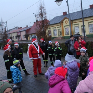 Dzieci przebrane za strażaków i mężczyzna przebrany za Świętego Mikołaja.