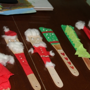 Ozdoby świąteczne zrobione przez dzieci ułożone w rzędzie na stole.